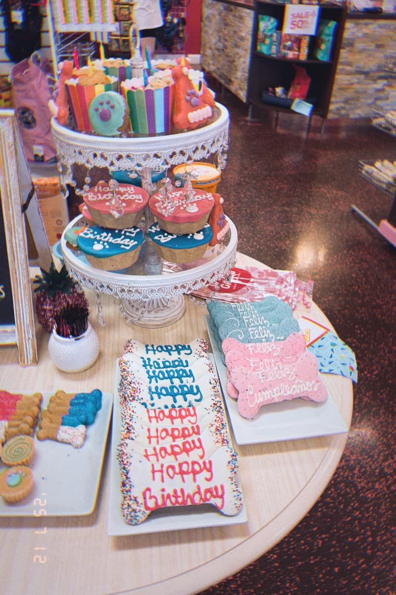 An in-store display of birthday dog cakes, iced bone cookies and tiered treat stands